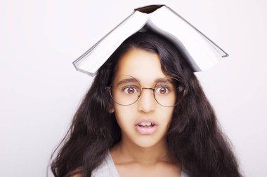 Sevimli kız gözlük ve kafasına kitap okuyor 