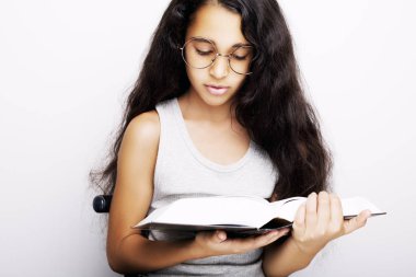 Sevimli kız gözlük ve beyaz arka plan üzerinde kitap okuyor