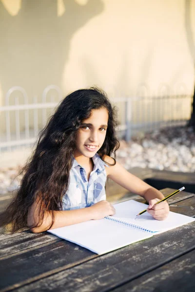 Güzel bir kız kalp parkta çizer.