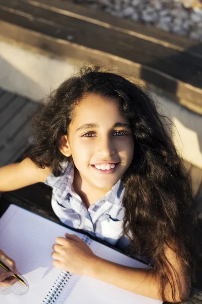 Güzel bir kız kalp parkta çizer.