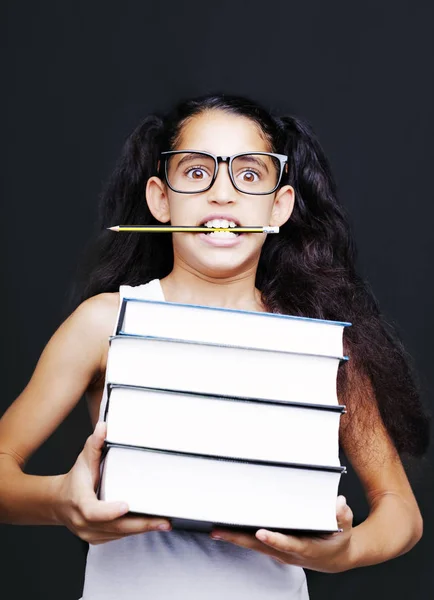 Malá dívka s brýlemi a tužku drží knihy — Stock fotografie