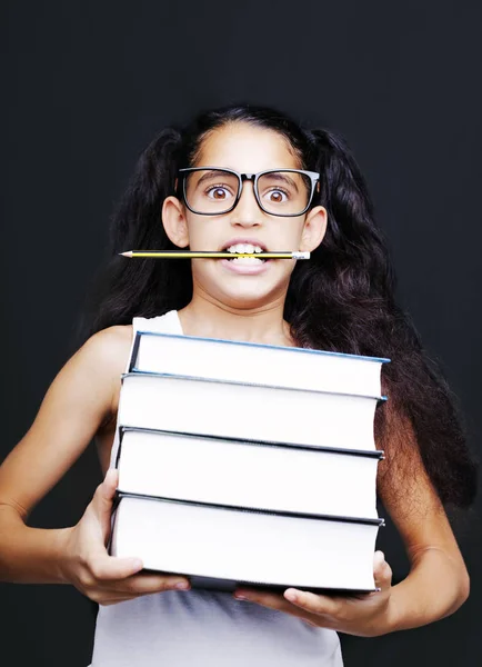 Kleines Mädchen mit Brille und Bleistift hält Bücher — Stockfoto