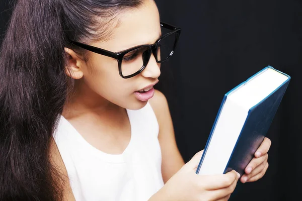 Entzückendes Mädchen mit Brille und Buch in der Hand — Stockfoto