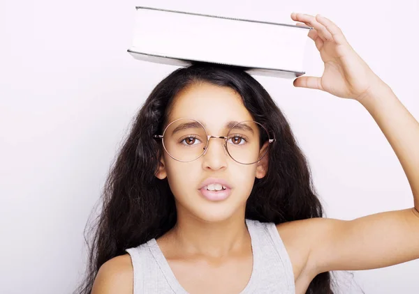 Entzückendes Mädchen mit Brille und Buch auf dem Kopf — Stockfoto