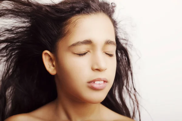 Retrato de uma menina com os olhos fechados virando o cabelo — Fotografia de Stock