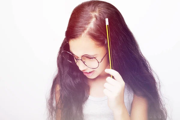 Une belle jeune fille africaine dans des lunettes tenant crayon à la main — Photo