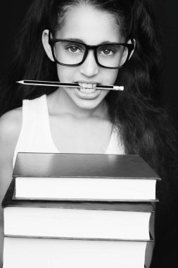 Gözlük ve kalem ile küçük kız kitapları tutar