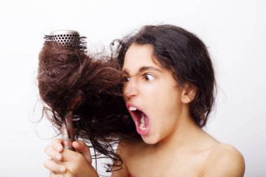 Üzerinde kızın portresi olan saç bakım konsepti. Asi, karmaşık saçlarını tarıyor. Beyazların üzerinde izole edilmiş.