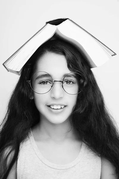 Imádnivaló lány tanul szemüvegek és a könyv a fejét — Stock Fotó