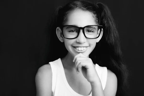 Adorable fille étudiant avec des lunettes sur fond noir — Photo