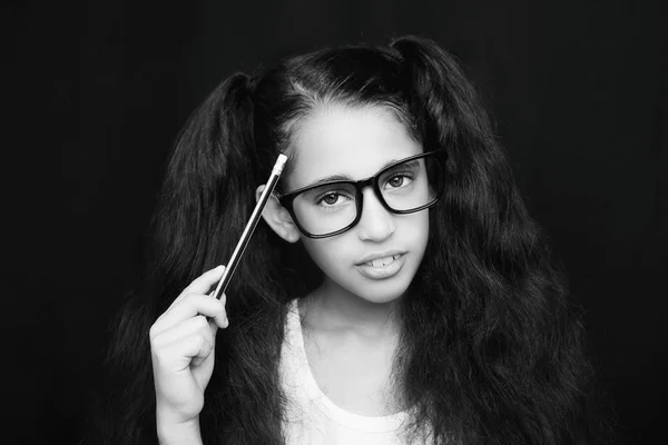 Una bella bambina africana in occhiali che tiene in mano la matita — Foto Stock