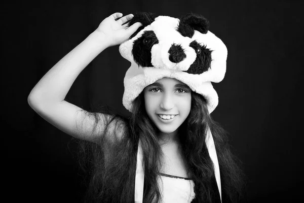 Porträtt av en bedårande flicka i panda hatt på svart bakgrund. — Stockfoto