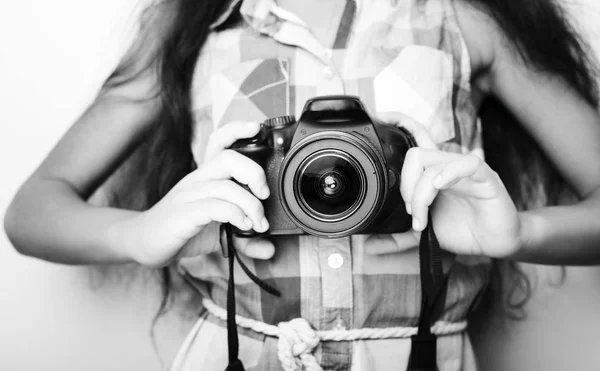 Cute brunette little girl holding an photo camera — Stock Photo, Image