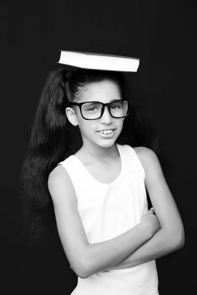 Schattig meisje studeren met brillen en boek op het hoofd — Stockfoto