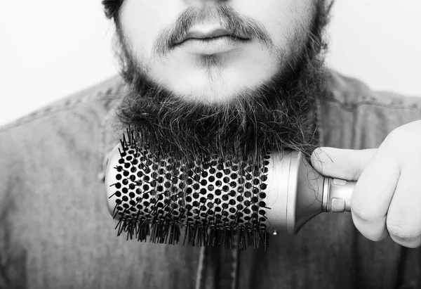 Retrato de um jovem elegante escovando sua barba — Fotografia de Stock