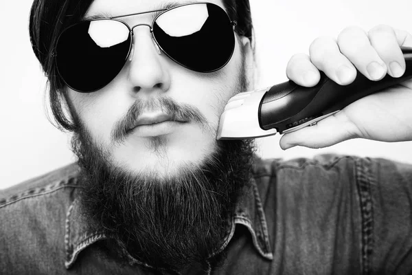 Homem jovem hipster barbear barba de gengibre com máquina de barbear elétrica . — Fotografia de Stock