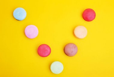 Tasty farklı macarons sarı arka plan üzerinde renkli