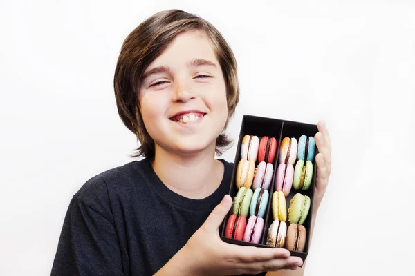 Щасливий усміхнений хлопчик тримає десертні макарони в дерев'яній коробці — стокове фото