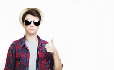 yakışıklı adam gösterilen başparmak yukarı üzerinde güneş gözlüğü ve şapka ile