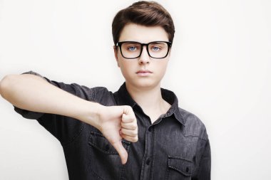 başparmak aşağı kamera beyaz arka plan üzerinde gösterilen sıradan genç adam