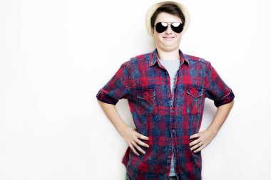 Güneş gözlüğü ve şapka üzerinde beyaz bir arka plan ile yakışıklı komik adam