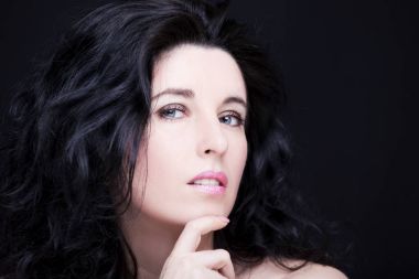 Uzun siyah saçlı, esmer, çekici bir kadın..