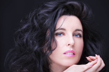 Uzun siyah saçlı, esmer, çekici bir kadın..