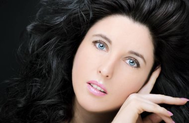 Uzun siyah saçlı, esmer, çekici bir kadın..