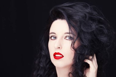 Uzun siyah saçlı, esmer, çekici bir kadın..