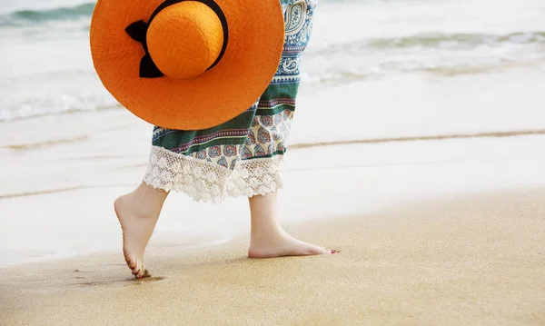 Босоногая женщина, гуляющая по океанскому пляжному песку и наслаждающаяся отдыхом во время туристической поездки — стоковое фото