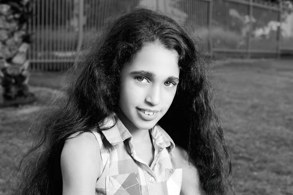 Menina encantadora bonita em jeans contra um fundo de grama verde — Fotografia de Stock