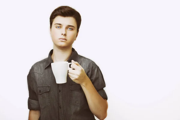 Pause café. Confiant jeune homme beau en jeans chemise tenant tasse avec boisson chaude — Photo