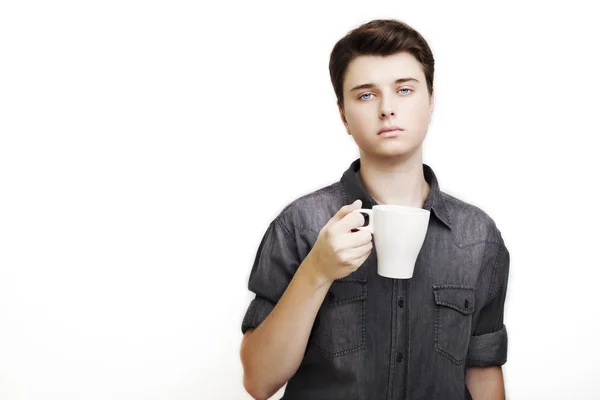 Koffiepauze. Zelfverzekerde jonge knappe man in spijkerbroek shirt houden cup — Stockfoto