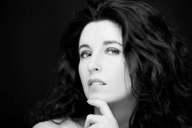 Uzun siyah saçlı, esmer, çekici bir kadın..