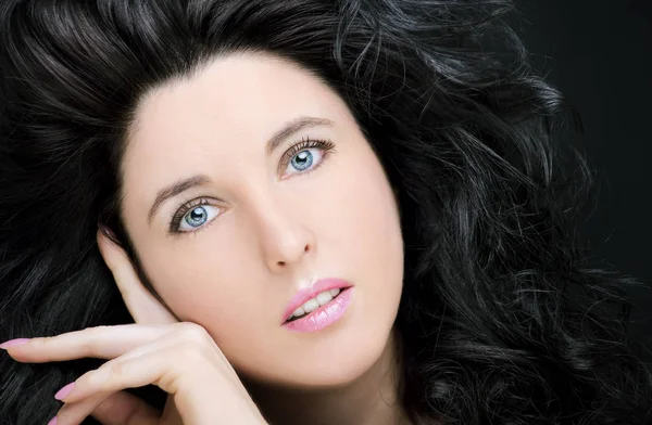 Uzun siyah saçlı, esmer, çekici bir kadın..