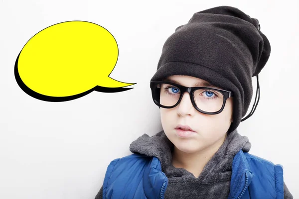 Der gutaussehende Junge trägt eine schwarze Mütze und eine Brille mit einer leeren Gedankenblase. isoliert auf weißem Hintergrund — Stockfoto