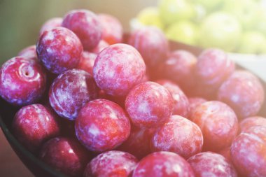 Olgun kırmızı Erik masada kase.