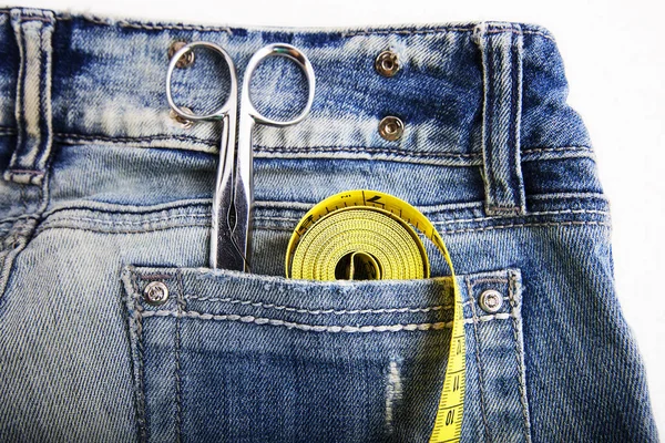 Metallscheren-Lineal und gelbes Maßband in Jeanshosentaschen. — Stockfoto