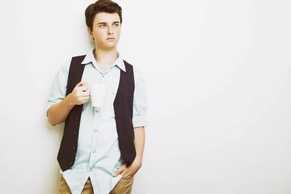 Αυτοπεποίθηση όμορφος νεαρός σε τζιν πουκάμισο κρατώντας κούπα με ζεστό ρόφημα — Φωτογραφία Αρχείου