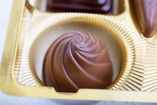 Uma coleção de chocolates mistos contra um fundo branco — Fotografia de Stock