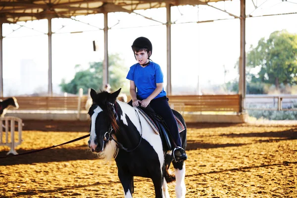 Portrait d'un petit garçon monté à cheval. Premières leçons d'équitation. — Photo