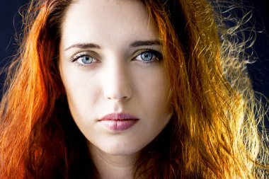 Uzun saçlı, mavi gözlü, düşünceli genç bir kızın portresi..