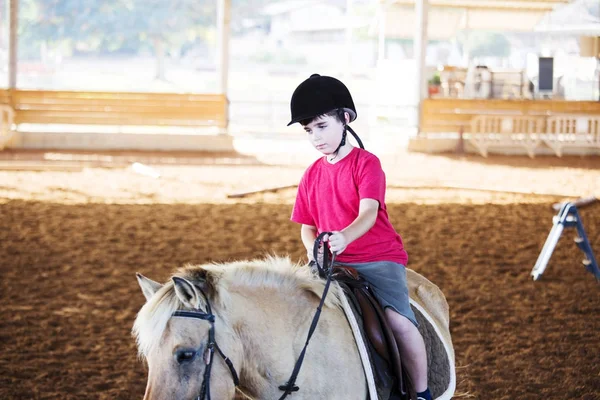 Ένα μικρό αγόρι Καβάλα σε άλογο. Πρώτα μαθήματα ιππασίας — Φωτογραφία Αρχείου