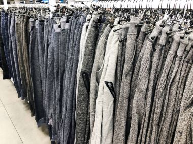 Erkek pantolon deposundaki bir askı üzerinde spor vardır. 