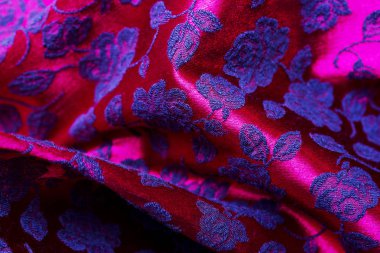 Kırmızı kumaş arkaplan rengarenk duvar halısı desenli ve çiçek süslemeli arka plan olarak kullanışlı..