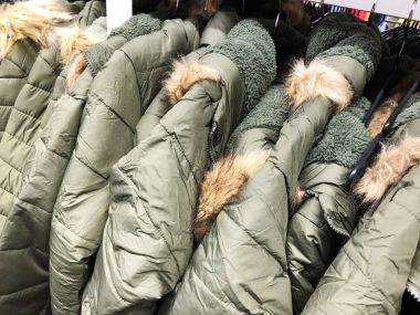 Erkek ve kadın'ın üstünde belgili tanımlık sayaç depodaki ceketler