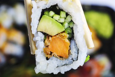Suşi holding tarafından chopsticks alır. Japon mutfağının geleneksel yemeği.