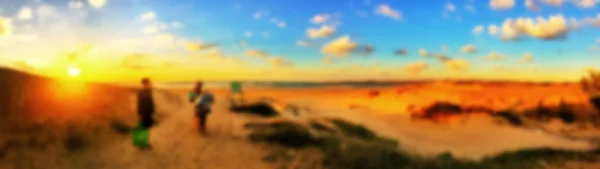 Persone offuscate che hanno la spiaggia al tramonto in vacanza estiva. Sfondo sfocato — Foto Stock