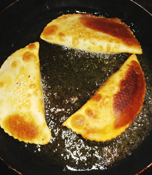 Cheburek με κρέας τηγάνισμα σε λάδι σε τηγάνι. Chebureks. Μαγειρεύω στο σπίτι — Φωτογραφία Αρχείου