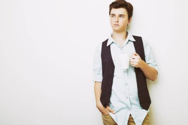 Emin yakışıklı delikanlı fincan sıcak bir içecek ile tutan kot gömlek